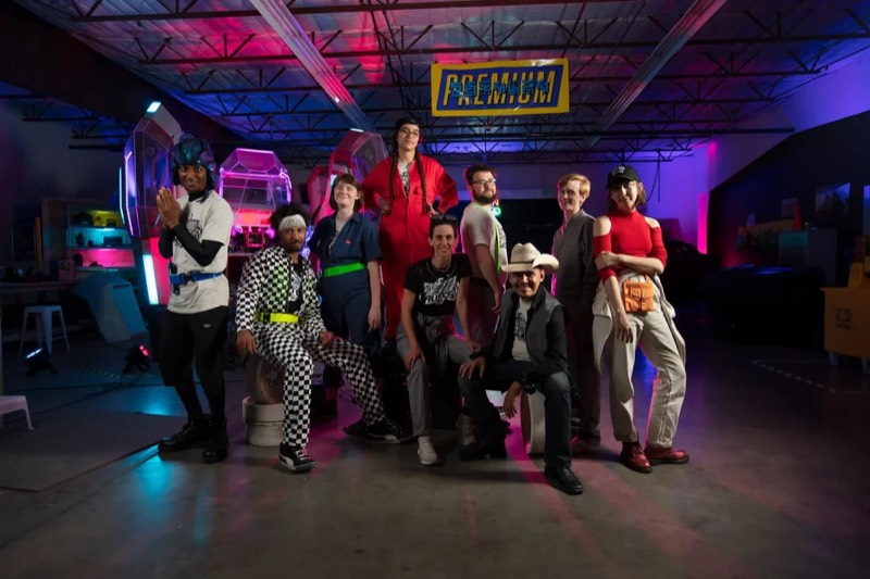 The performers and crew posed together in the garage set