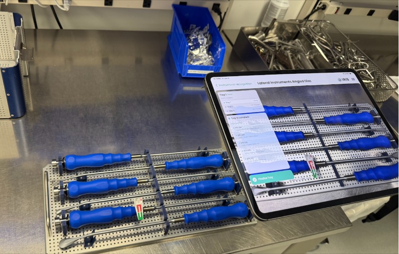 The IRIS app on a tablet next to a tray of surgical instruments