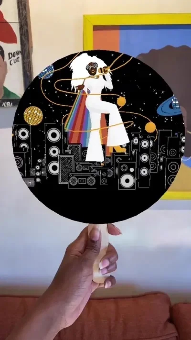 A hand holding the Obsidiopolis church fan with an AR portal over it
